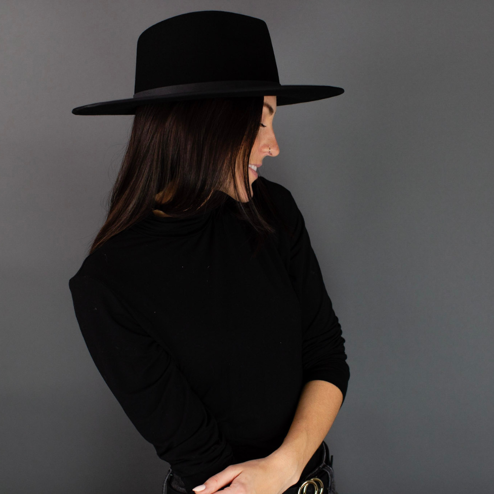 The Black Wide Brim Fedora with Leather Band, an embodiment of timeless sophistication. This elegant fedora features a wide brim and a sleek black leather band, combining classic style with modern sensibility. A versatile accessory that exudes refinement, it's the perfect choice to elevate your fashion game for any occasion.